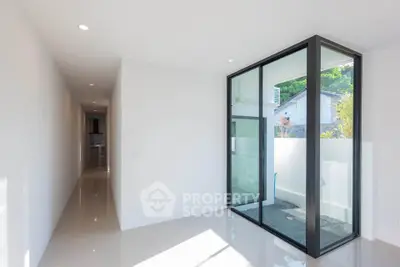 Bright modern interior with large glass windows and sleek hallway, perfect for contemporary living.