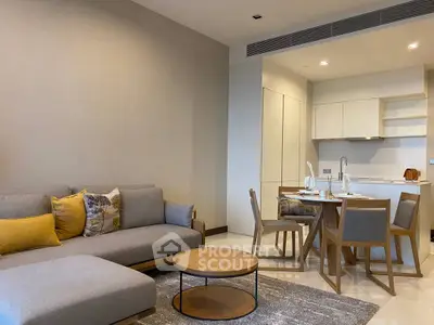 Modern living room with open kitchen, stylish furniture, and elegant decor in a cozy apartment.