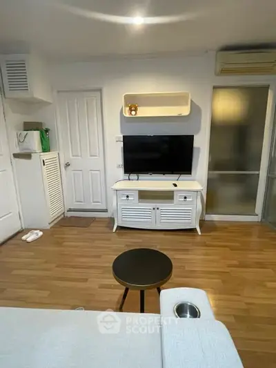 Cozy living room with modern TV setup and wooden flooring