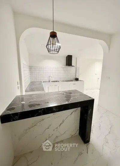 Modern kitchen with marble countertops and open layout in stylish apartment.