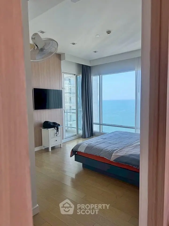 Stunning bedroom with ocean view and modern decor, featuring floor-to-ceiling windows and sleek furnishings.