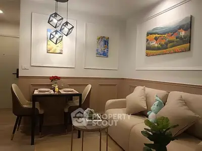 Cozy living room with modern decor and dining area, featuring elegant lighting and wall art.