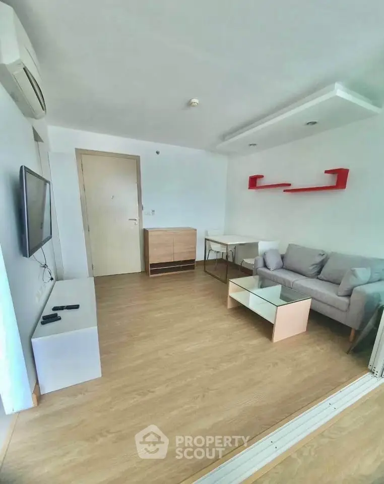 Modern living room with sleek furniture and wooden flooring, perfect for cozy urban living.