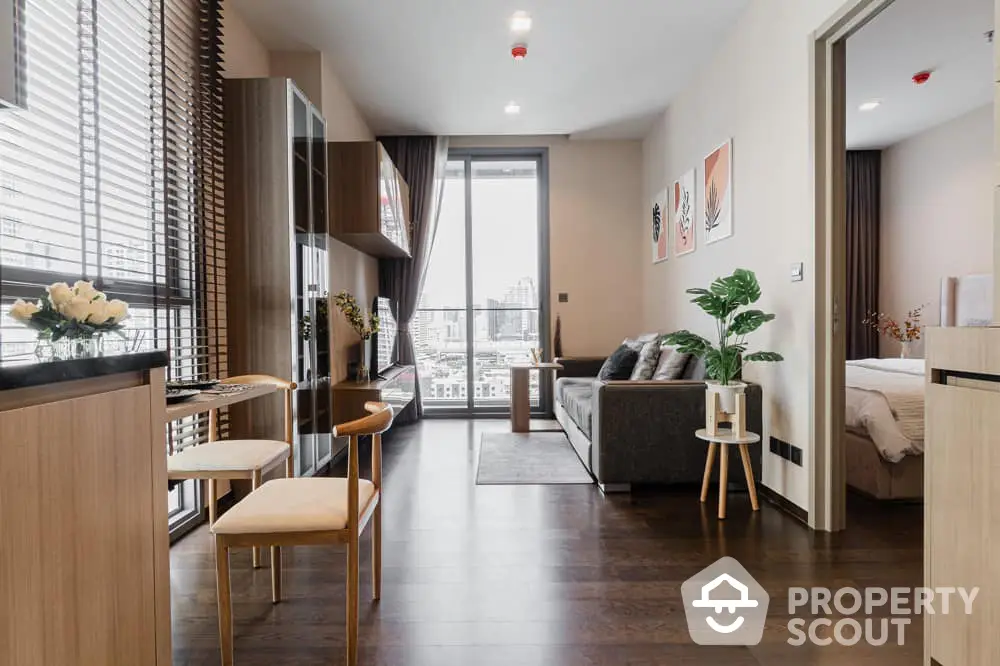 Modern studio apartment with open layout, sleek furnishings, and abundant natural light from floor-to-ceiling windows leading to a cozy balcony.