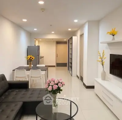 Modern open-plan living room with sleek furniture and elegant decor in a stylish apartment.