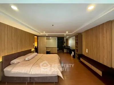 Spacious modern bedroom with elegant wood paneling and ambient lighting