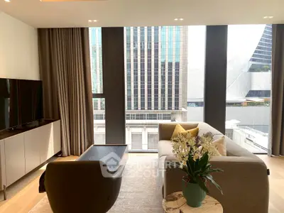 Modern living room with large windows offering stunning city views, featuring elegant furniture and decor.