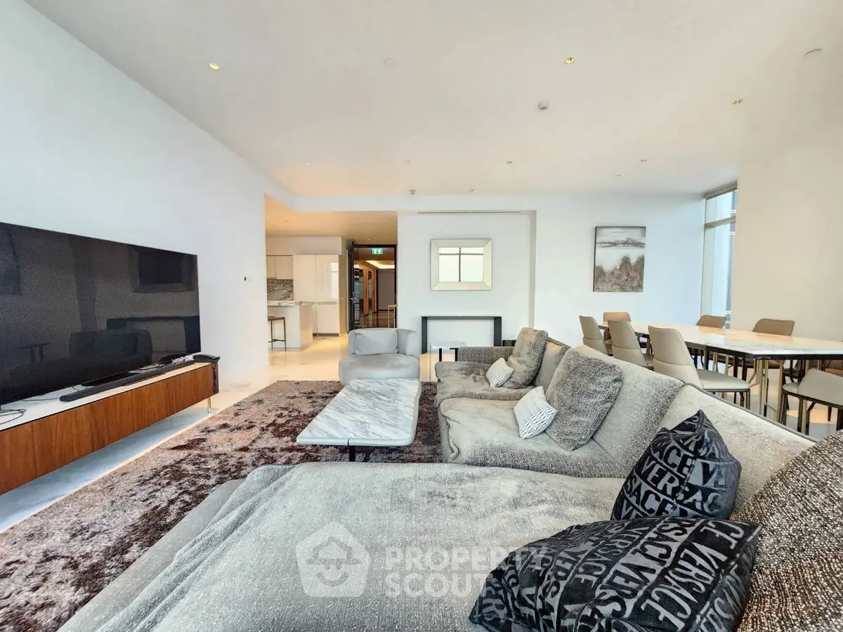 Spacious modern living room with plush seating and large TV, perfect for relaxation and entertainment.
