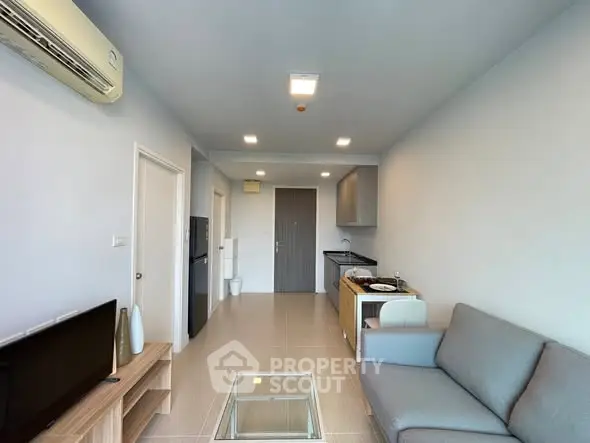 Modern living room with open kitchen layout and sleek furnishings