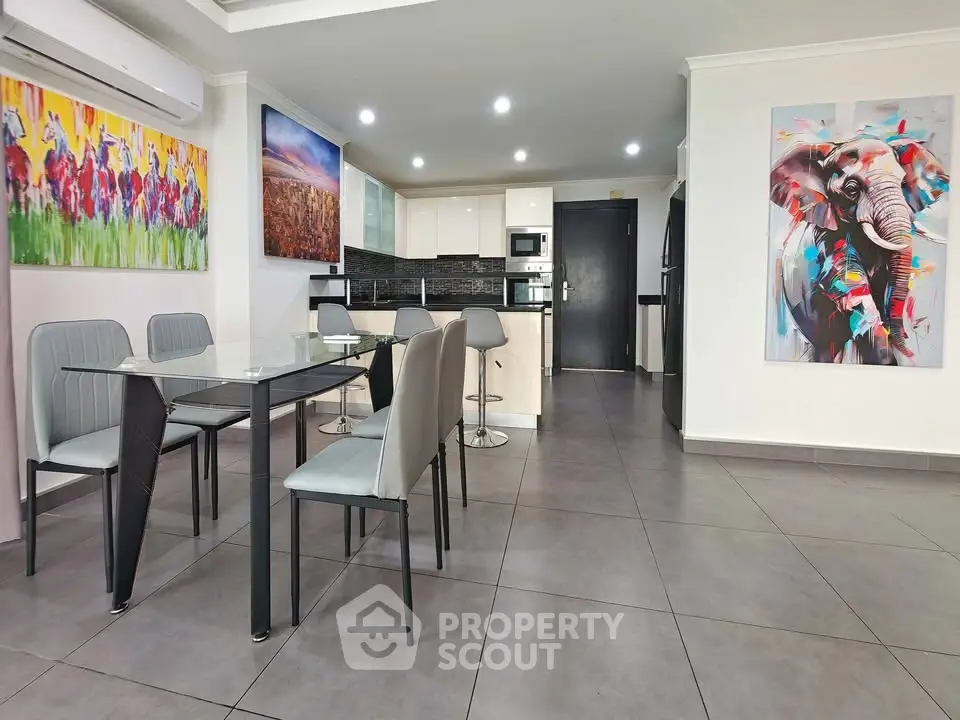 Modern open-layout kitchen and dining area with stylish decor and vibrant artwork.