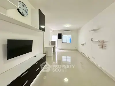 Modern minimalist living room with sleek TV unit and wall clock