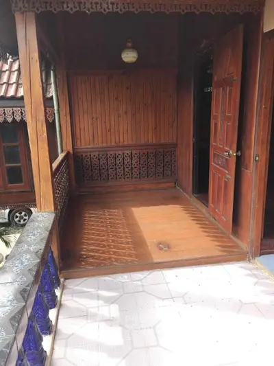 Charming wooden balcony with intricate railing design and open door