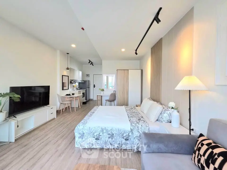 Modern studio apartment with open layout, featuring cozy living area and stylish kitchen.