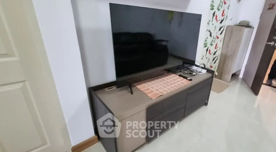 Modern living room with sleek TV stand and large flat-screen TV, perfect for entertainment.