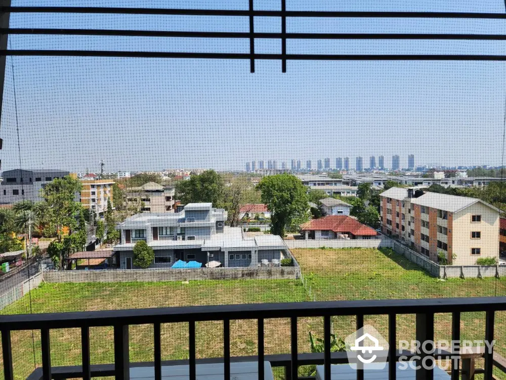 Stunning cityscape view from a high-rise balcony overlooking residential and urban skyline.