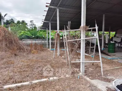 Spacious outdoor area with potential for development, featuring a covered structure and natural surroundings.