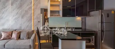 Modern open-layout kitchen with sleek black countertops and integrated living area.
