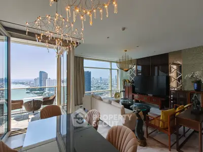 Luxurious living room with stunning city and river views, elegant decor, and modern lighting fixtures.