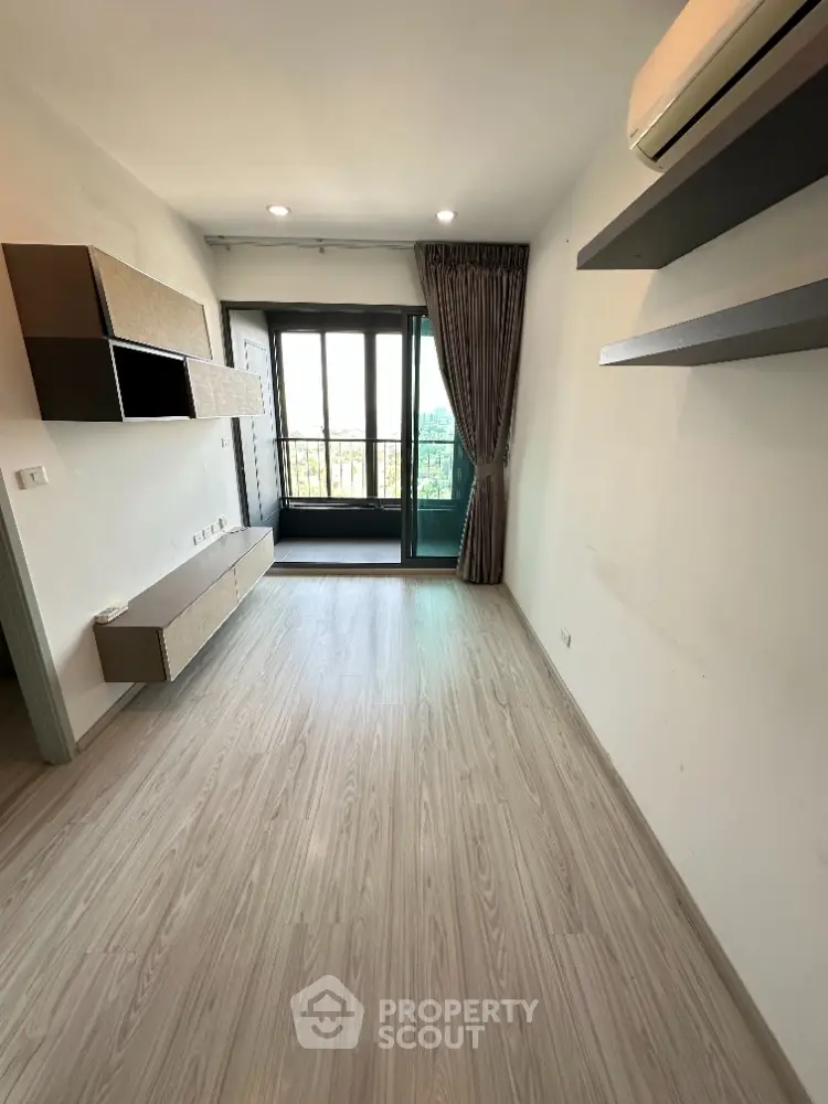 Spacious living room with modern design and large windows leading to a balcony.