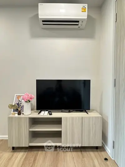 Modern living room with sleek TV unit and air conditioning, perfect for cozy relaxation.