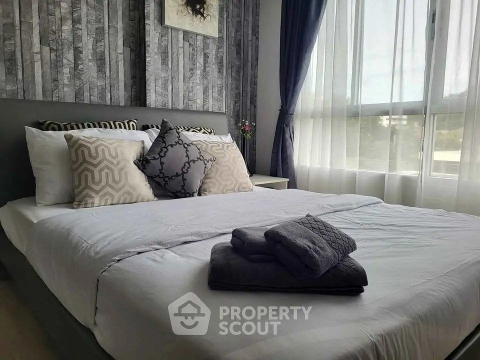 Modern bedroom with stylish decor and large window for natural light.