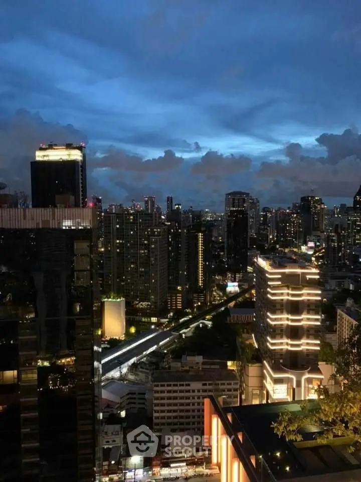 Stunning cityscape view from a high-rise building at dusk, showcasing vibrant city lights and skyline.