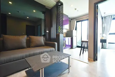 Modern living room with sleek design and open kitchen layout, featuring stylish furniture and natural light.