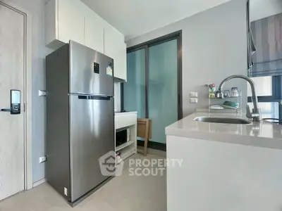 Modern kitchen with sleek appliances and minimalist design in a contemporary apartment.