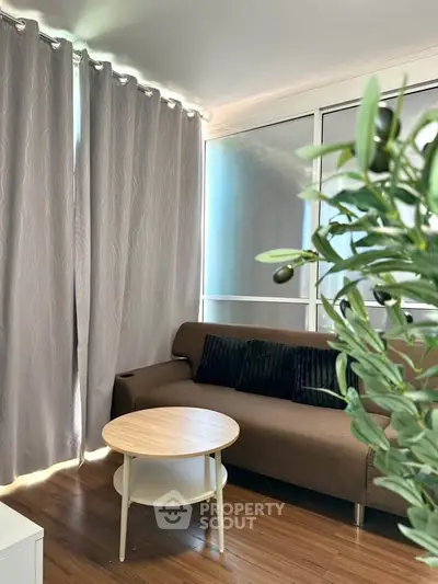 Cozy living room with brown sofa, round table, and elegant curtains