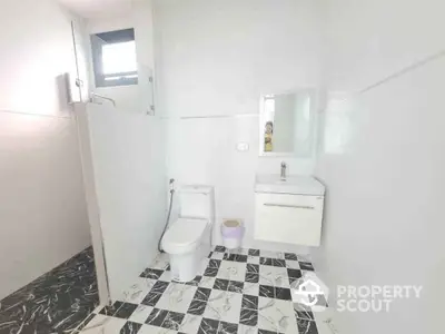 Modern bathroom with stylish black and white tile flooring and sleek fixtures