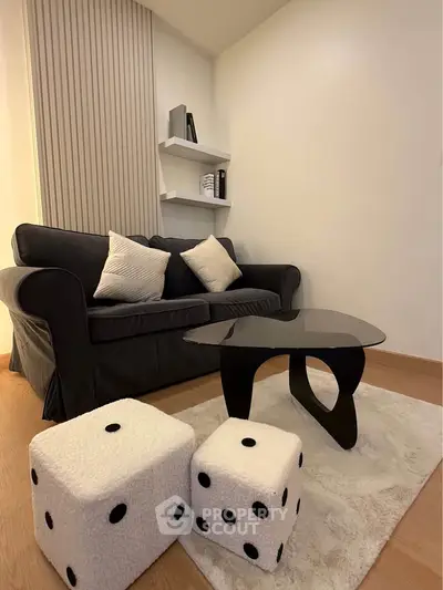 Modern living room with stylish black sofa and unique dice-shaped stools