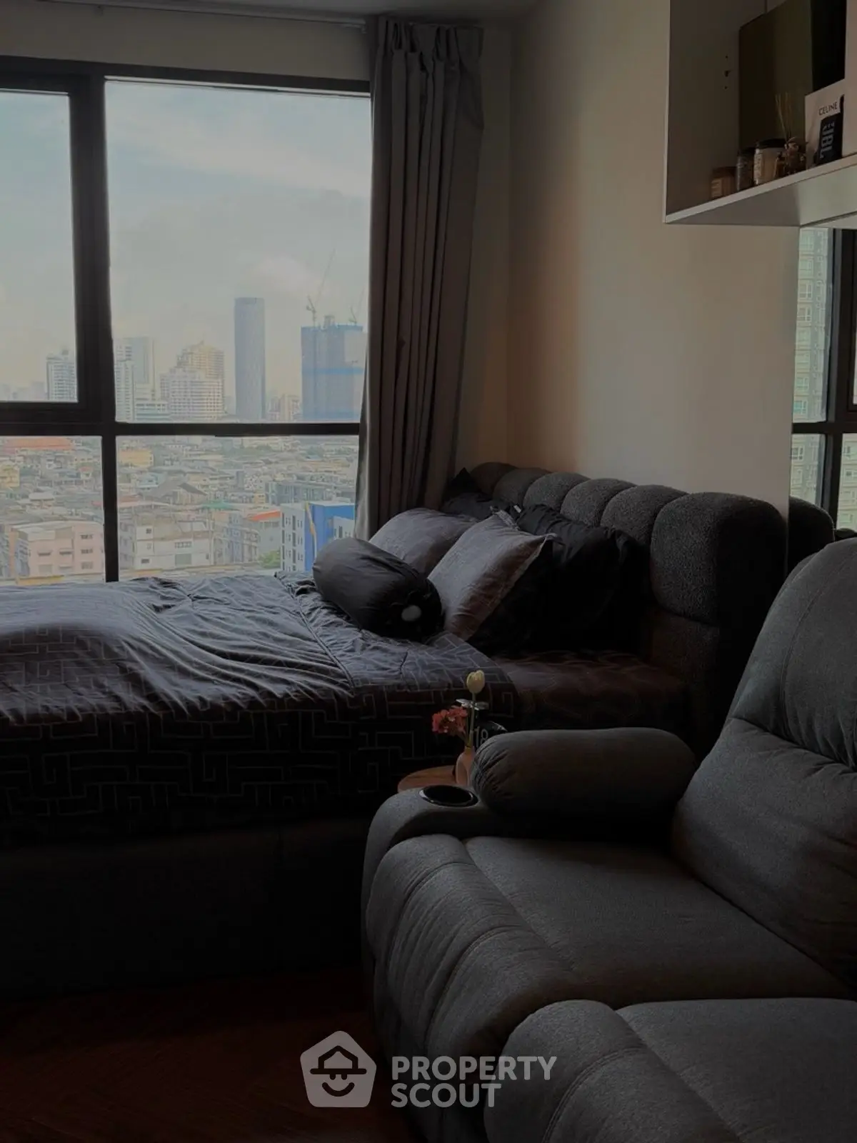 Cozy bedroom with city view and plush seating, perfect urban retreat.