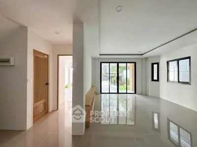 Spacious modern living room with large windows and glossy tiled floors