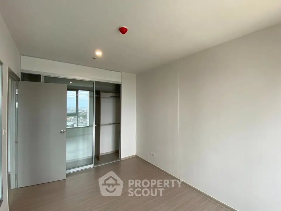 Spacious empty bedroom with large closet and city view, perfect for customization.