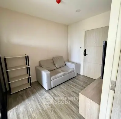 Cozy living room with modern decor and wooden flooring in a compact apartment.