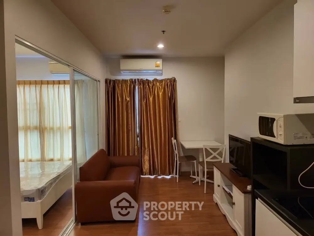 Modern apartment with cozy living room and bedroom, featuring wooden flooring and stylish furnishings.