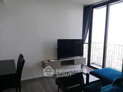 Modern living room with sleek furniture and large balcony view.