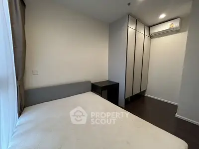 Cozy bedroom with modern wardrobe and air conditioning, perfect for comfortable living.