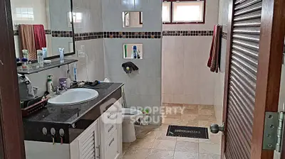 Spacious bathroom with modern fixtures and ample storage space.