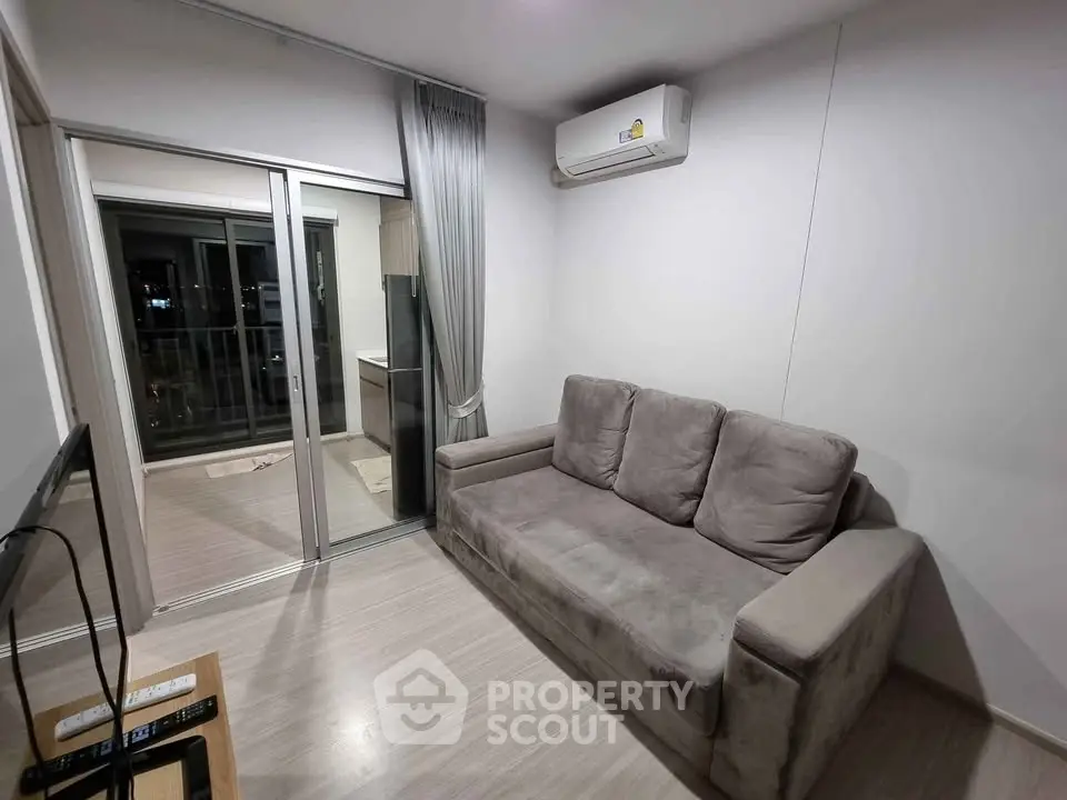 Modern living room with cozy sofa and air conditioning, featuring a balcony view.