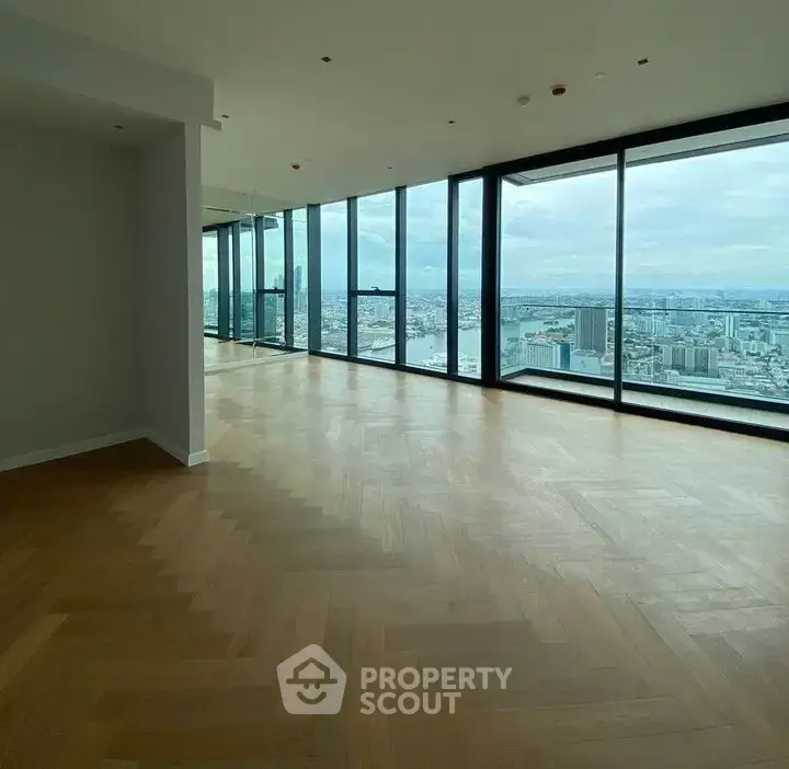 Spacious modern living room with panoramic city views and elegant wooden flooring.