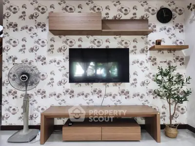 Stylish living room with modern TV setup and floral wallpaper, featuring elegant wooden furniture and decor.
