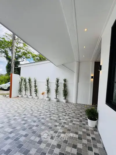 Modern exterior with sleek design and potted plants, showcasing stylish architecture.