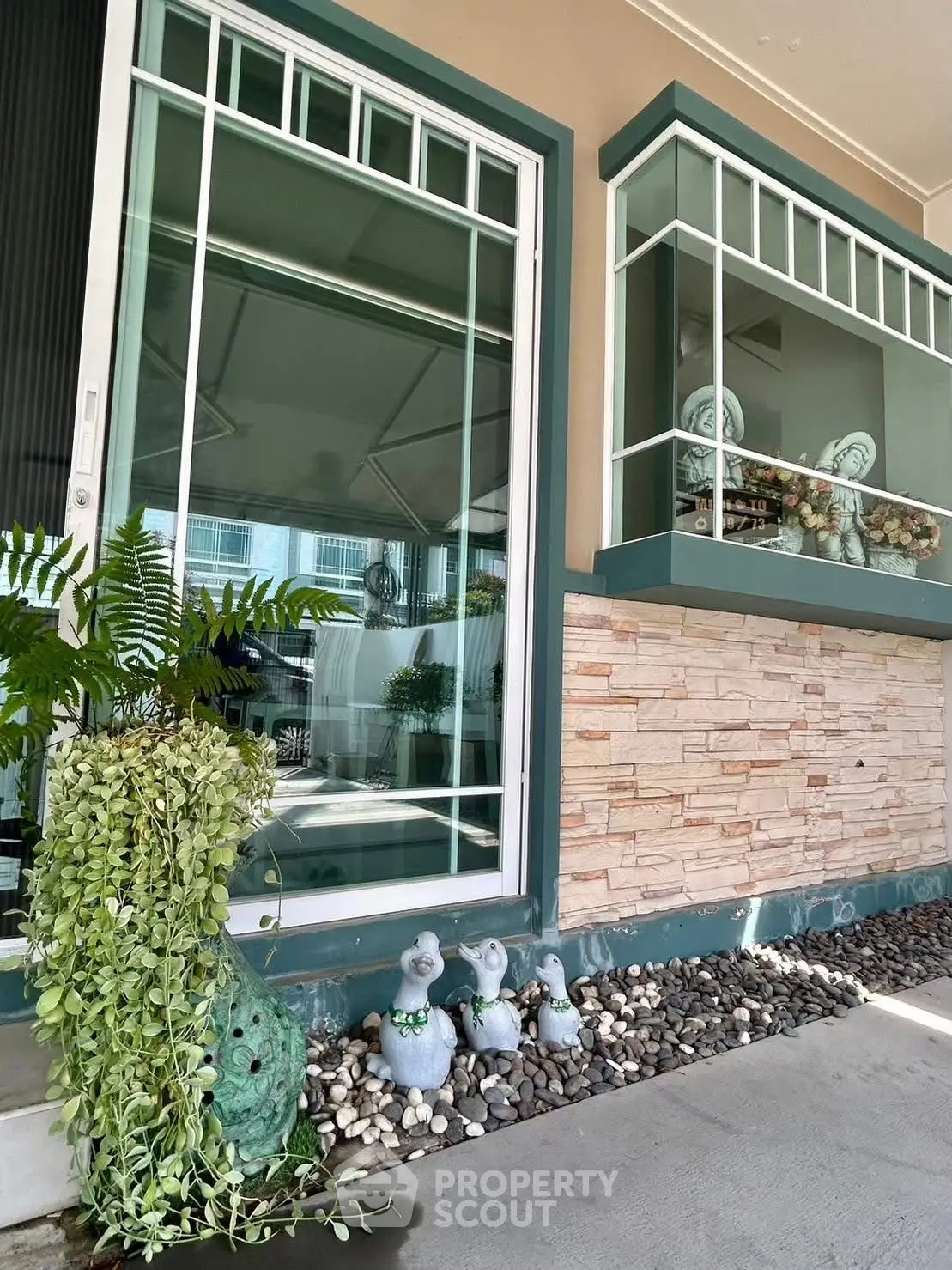 Charming exterior with decorative stonework and lush greenery