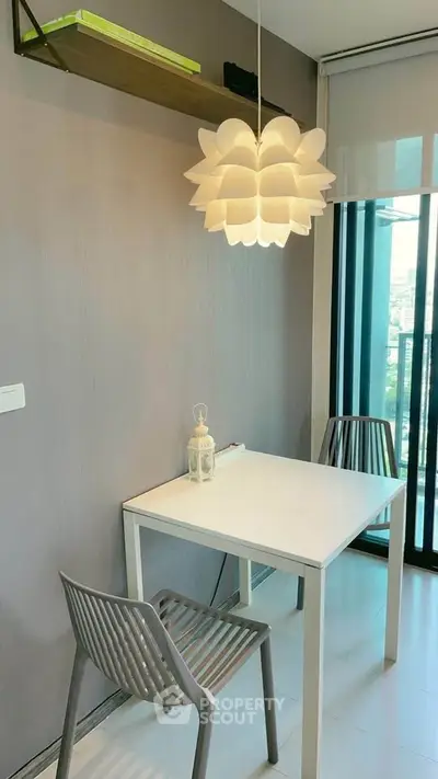 Modern dining nook with stylish pendant light and city view