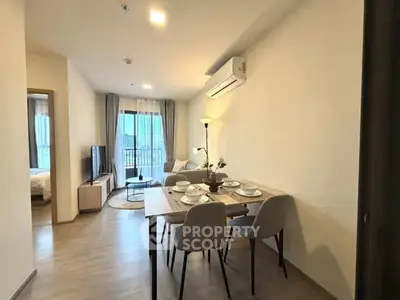Modern living room with dining area and natural light in a stylish apartment.
