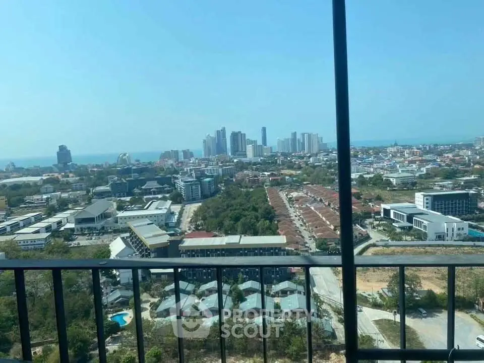 Stunning cityscape view from high-rise balcony overlooking urban skyline and distant ocean.