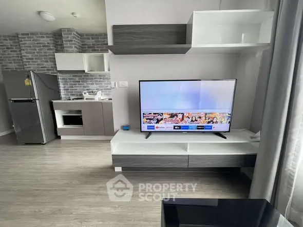 Modern living room with sleek TV setup and stylish kitchen area