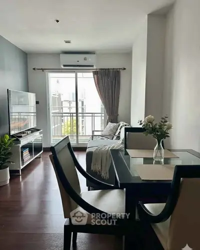 Modern living room with dining area, large window, and stylish decor in a cozy apartment.