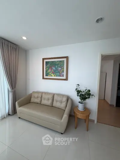 Elegant living room with cozy sofa, stylish decor, and natural light from large window.